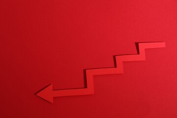 One zigzag paper arrow on red background, top view. Space for text
