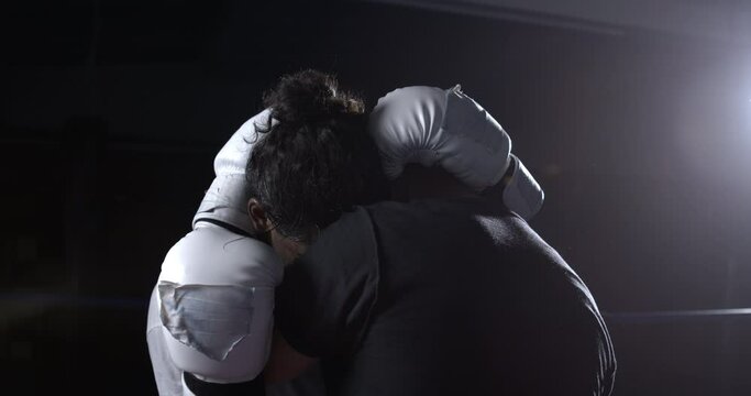 Fighters wrapped during battle inside ring to prevent kicks and punches captured in slow-motion, clinched position