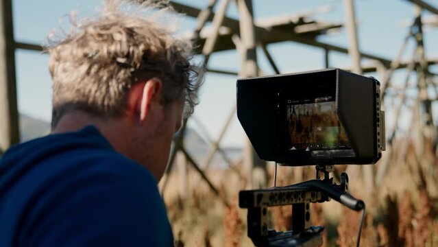 Filmmaker Looking At The Camera's Smart Monitor