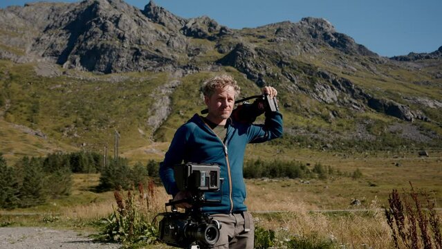 Man Carrying Recording Equipment While Walking
