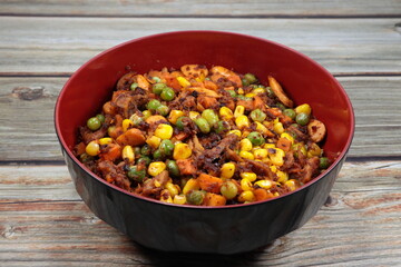 Spicy vegetarian salad with mixed grain, sweet corn, carrot and mushroom serving in the bowl. Famous appetizer menu in Asian restaurant.