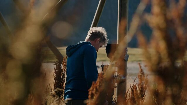 Man Filming With A Camera Near Curly Dock
