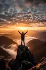 Man standing on top of mountain peak celebrating holding up arms. - obrazy, fototapety, plakaty