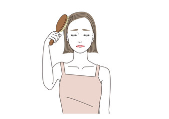 髪の毛をブラッシングしながら辛そうな表情の女性