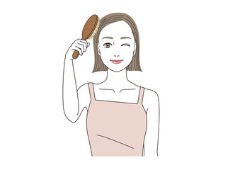 髪の毛をブラッシングしながらウインクしている笑顔の女性