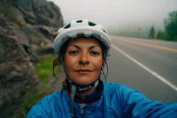 Bike helmet - woman putting biking helmet on outside during bicycle ride.
