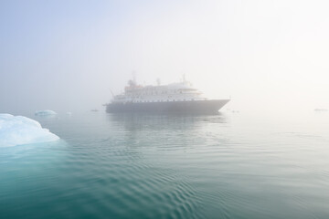 Arctic cruise ship early in the morning on a sunny and foggy day, Liefde Fjord, Svalbard

