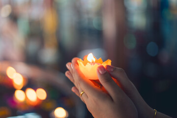 Young Asian woman holds a Krathong in her hand. She is praying for good things in life.