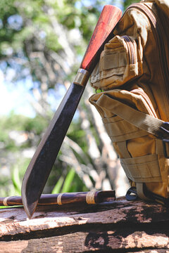 Spata knife with backpack for survival in the forest on an old timber