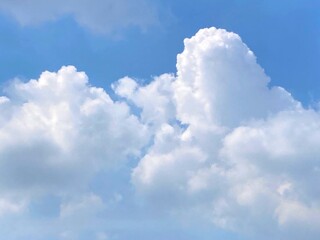 Naklejka na ściany i meble Fluffy cumulus clouds with sunlight in the blue sky for background or illustration