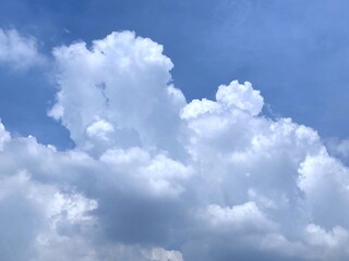 Fluffy cumulus clouds with sunlight in blue sky for background or illustration