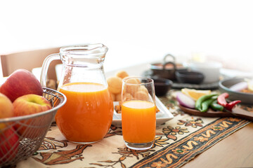 Orange juice in a pitcher and traditional Indian food on the dining table, ready to eat