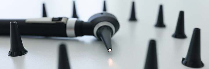 Modern otoscope with light on tip and caps for ear checkup - obrazy, fototapety, plakaty