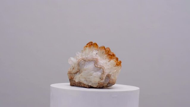 Citrine golden quartz crystal druzy mineral for therapy energy healing yellow rock rotating shot on white surface