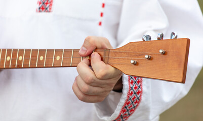 A man plays the balalaika. Close-up
