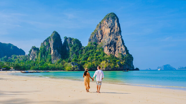Railay Beach Krabi Thailand, the tropical beach of Railay Krabi, a couple of men and women on the beach, with a view of idyllic Railay Beach in Thailand