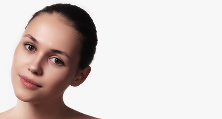 Fototapeta premium Beautiful natural girl smiling, looking happy. Portrait of a young woman with natural makeup . Care cosmetics, face and body skin care.