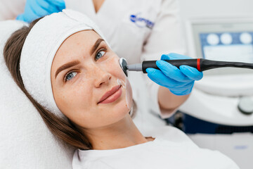 Close-up of a young woman's face during microcurrent therapy. Procedure for electrical stimulation of the face, rejuvenation, anti-wrinkle. The concept of youth and modern cosmetology technologies.