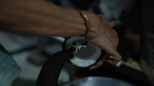 close up video clip of coconut grating manually by hand in home of India