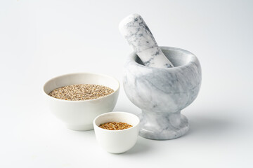 Marble mortar and pestle with spices on white background