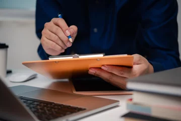 Foto op Plexiglas man holding clipboard with checklist employee workplace is reviewing documents © khunkornStudio