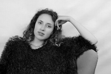 Sie sitzt in ihrem Pullover lässig in den Stuhle gelehnt