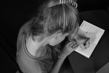 Junge Frau macht sich stillsitzend Notizen in ihr persönliches Tagebuch