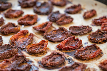 Pile of sundried or dried tomato halves on baking tray