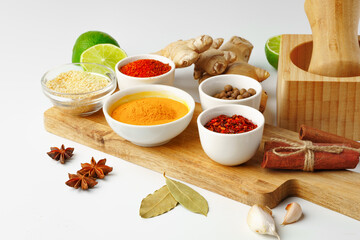 Wooden mortar with spices on white background