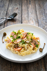 Tagliatelle with salmon and mayonnaise on wooden table
