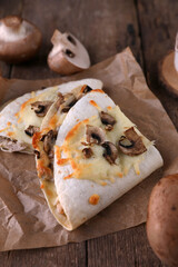 Quesadilla with mushrooms and chicken on wooden background