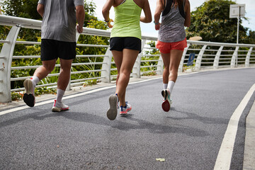 close-up of legs and feet of young asian people running jogging outdoors - obrazy, fototapety, plakaty