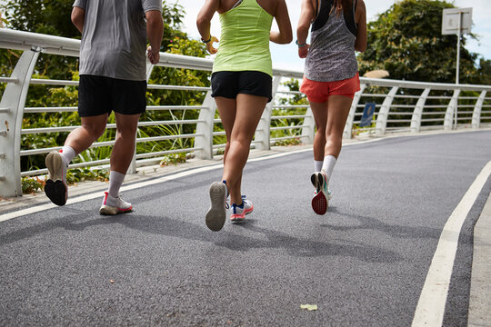 close-up of legs and feet of young asian people running jogging outdoors