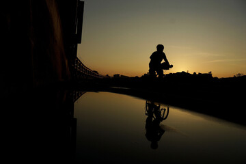 A person riding a bicycle at dusk. © ElsaJao