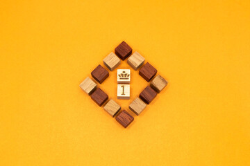 赤と黄色のブロックをひし形に並べたオレンジの背景の1位のシンボル
