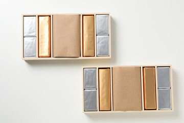 Chocolate candies in boxes on white background, top view