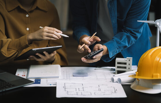brainstorming and measuring for cost estimating on paperworks and floor plan drawings about design architectural and engineering for houses and buildings.