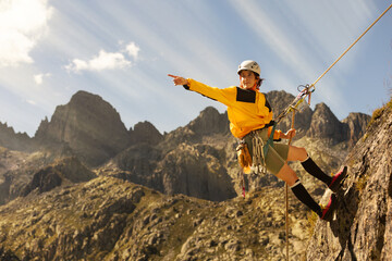 woman climbing in the mountain at sunset with lus rays, security, confidence business woman, rope...