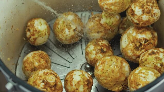 Food preparation for restaurants and canteens. Several celeriac being tossed around in cleaning process. High quality 4k footage