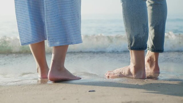 Couple spending time together on sea beach at sunset, closeup