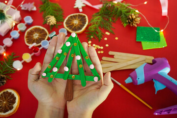 Step by step instruction how to make christmas tree from ice cream sticks. Step 4 Child's holding...