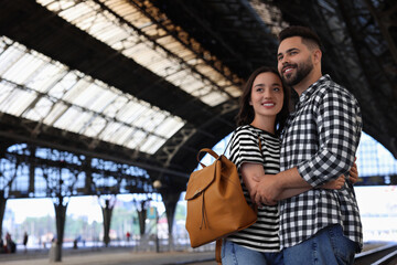 Long-distance relationship. Beautiful couple on platform of railway station, space for text