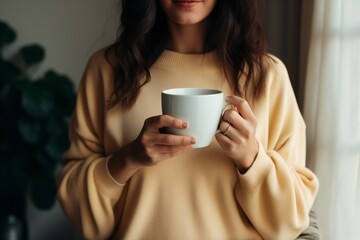 Woman holding a cup of coffee. Drink morning. A girl in a cozy house drinks a hot drink