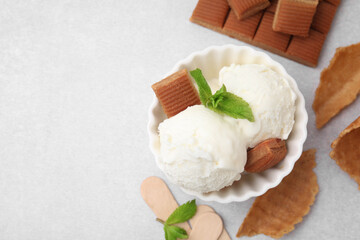 Scoops of tasty ice cream with mint and caramel candies on white table, flat lay. Space for text