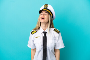 Airplane pilot over isolated blue background laughing