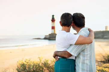 Mature Couple Embracing At Ocean View With Lighthouse Outdoor