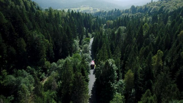 4k Drone Shot of Fire Truck Driving in Stunning Forest Landscape Scenery