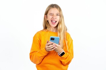 Excited Beautiful teen blonde girl   winking and eye hold smart phone use read social network news