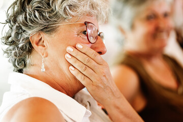 senior woman cries emotionally at a family event