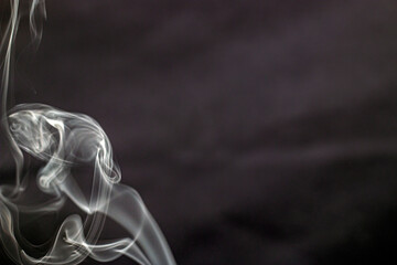 Bizarre beautiful forms of smoke from incense fly in the air on a black background	
